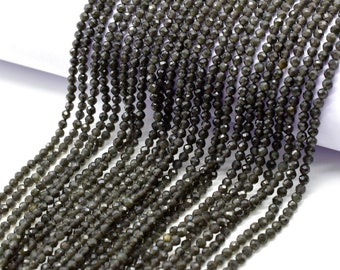 May include: A strand of dark gray faceted gemstone beads. The beads are small and uniform in size, and they are strung on a clear thread.