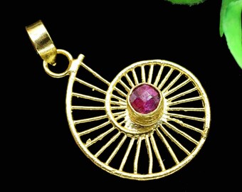 May include: Gold pendant with a spiral design and a pink gemstone in the center.