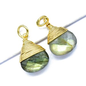 May include: Two gold-wrapped labradorite gemstone pendants. Each pendant features a teardrop-shaped stone with a green and gray iridescent sheen.
