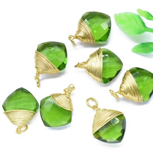 May include: Eight green gemstone pendants with gold wire wrapping. The gemstones are faceted and have a square shape. The pendants are strung on a gold chain.