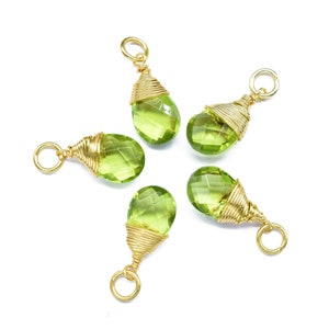 May include: Five green gemstone pendants with gold wire wrapping. Each pendant has a gold loop for attaching to a chain or cord.