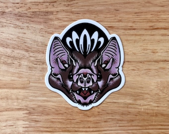 May include: A sticker featuring a detailed illustration of a bat's face with a black background and white floral design.