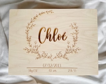 May include: A wooden keepsake box with a gold engraved floral wreath and the name "Chloe". The box also includes the date "07/12/2013", weight "3 kg C30", height "49 cm", and time "21h 55".