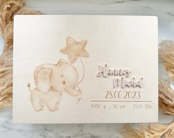 May include: A wooden keepsake box with an engraved elephant design, a star, and the name Hannes Michael. The box also includes the date 28.06.2023, weight 4450 g, height 56 cm, and time 15:14 Uhr.