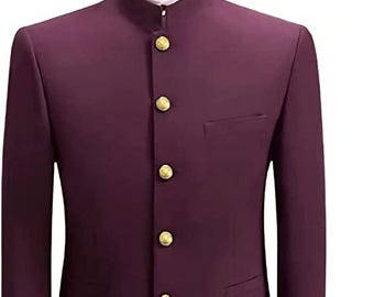 May include: A formal burgundy suit with a mandarin collar, featuring gold buttons and a matching pair of trousers. The suit has a tailored fit, with a pocket on the jacket. The trousers are neatly folded.