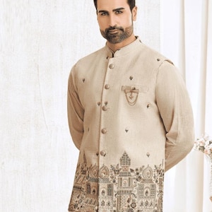 May include: Beige kurta pajama set with a matching vest featuring an embroidered architectural design. The outfit includes a mandarin collar and button-down vest. The Indian Darzi logo is visible.