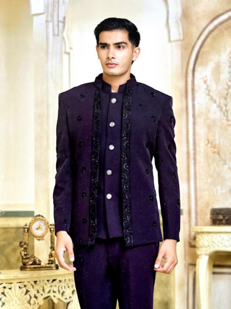 May include: A dark purple suit with a mandarin collar, featuring decorative black embroidery and silver buttons. The suit includes a jacket and matching pants, suitable for formal occasions.