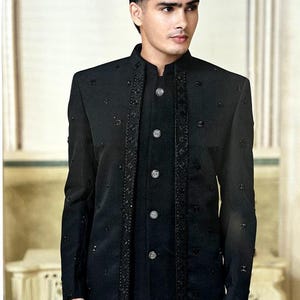 May include: A black formal jacket with a mandarin collar and decorative embellishments. The jacket features a button-down front and is paired with a matching black shirt. The overall style is elegant and suitable for formal occasions.