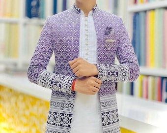 May include: A purple and white patterned jacket with a mandarin collar and ornate cuffs. The jacket is worn over a white shirt with a button-up front. A pocket square and a small pin are visible on the jacket.