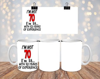 May include: Two white coffee mugs with black rims. One mug has a black and red design that says "I'm not 70. I'm 18... with 52 years of experience."