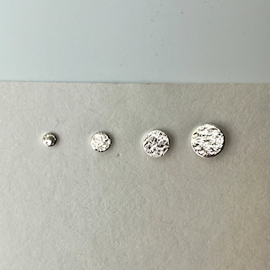 Op de afbeelding: Drie ronde, getextureerde zilveren oorringen in verschillende maten.