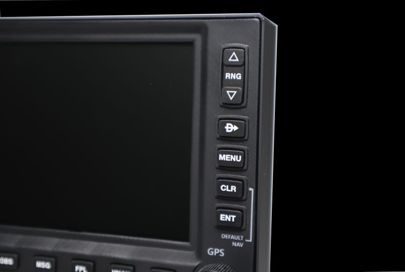 May include: Close-up of a black electronic device with a screen and buttons. The buttons are labeled with text such as "RNG", "MENU", "CLR", and "ENT". The device has a GPS function.