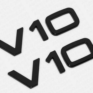 May include: Two black plastic emblems with the text "V10" in a bold, stylized font.