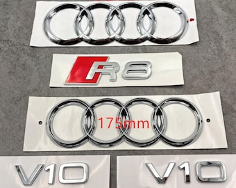 May include: Chrome car emblems, including two sets of four interlocking rings, one measuring 192mm and the other 175mm. Also included is a red and silver "R8" emblem and two "V10" emblems. All emblems are on white backing.