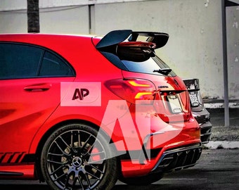 May include: A red hatchback car with black accents, a rear spoiler, and black rims. The car has a sporty design and is parked on a city street. The image has a watermark with the letters "AP".