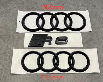 May include: Black car emblem set, including two sets of four interlocking rings and an "R8" emblem. The larger ring set measures 192mm, and the smaller set is 175mm. All emblems are on white backing.