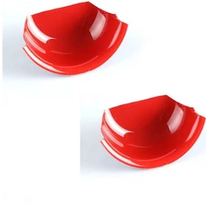 May include: Two red plastic bowls with a chipped edge. The bowls are shallow and have a glossy finish.