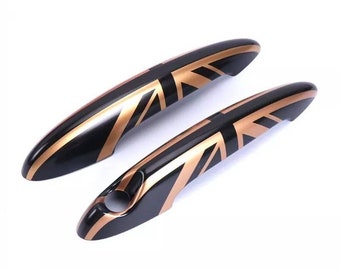 May include: A pair of black car door handles with a gold Union Jack design.