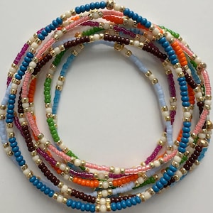 May include: A colorful beaded bracelet with multiple strands of different colors, including blue, green, pink, orange, brown, and white.