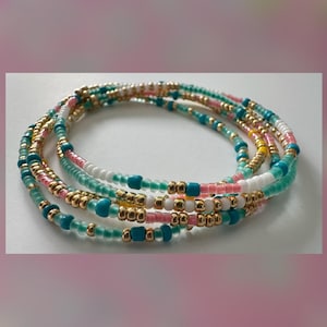 May include: A multi-strand beaded bracelet with turquoise, white, pink, and gold beads.