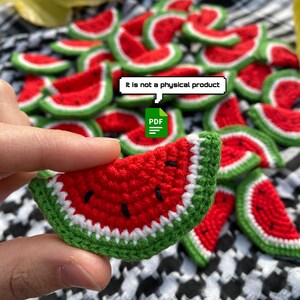 May include: A PDF pattern for crocheting watermelon slices. The pattern includes instructions for making the slices in red, green and white yarn. The image shows a hand holding a finished crocheted watermelon slice.