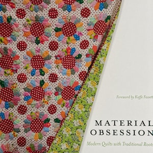 May include: A quilt featuring a repeating pattern of multi-colored fabric flower motifs with red polka-dot centers on a cream background, displayed next to a book titled Material Obsession: Modern Quilts with Traditional Roots by Kathy Doughty and Sarah Fielke.