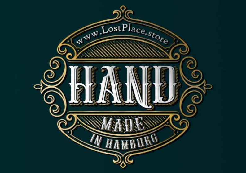 Op de afbeelding: Een gouden en wit logo met sierlijke details. Het logo zegt "HAND MADE IN HAMBURG" en "www.LostPlace.store".