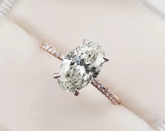 May include: A rose gold engagement ring with a large oval-shaped diamond and a pave diamond band.