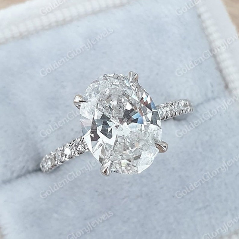 Op de afbeelding: Een zilveren verlovingsring met een grote ovale diamant en een pav&eacute;-diamanten band.