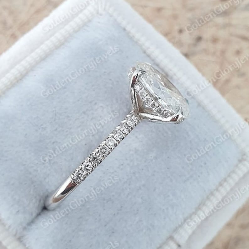 Op de afbeelding: Een zilveren verlovingsring met een grote ovale diamant als middelste steen en een pav&eacute;-diamanten band.