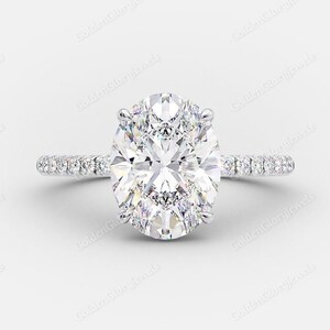 Op de afbeelding: Een zilveren verlovingsring met een grote ovale diamant als middelste steen en een pav&eacute;-diamanten band.