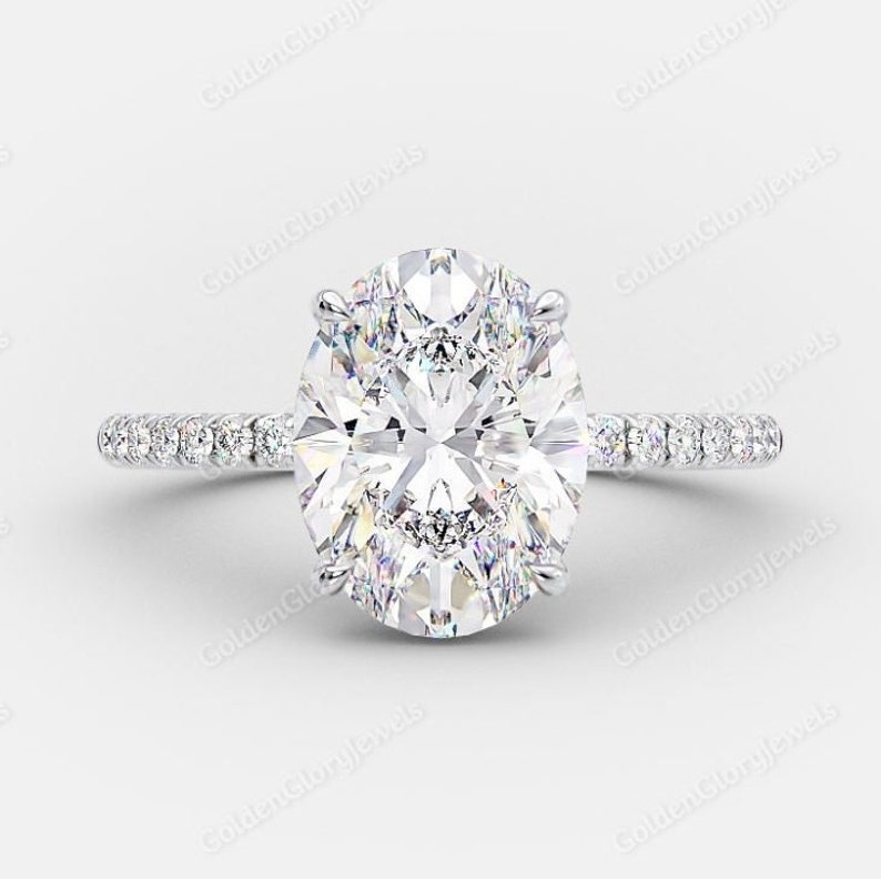 Op de afbeelding: Een zilveren verlovingsring met een grote ovale diamant als middelste steen en een pav&eacute;-diamanten band.