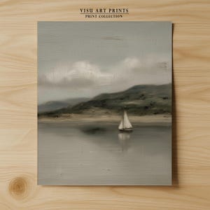 May include: A serene landscape painting featuring a sailboat on calm water, with a backdrop of rolling hills and a cloudy sky. The artwork is in muted tones of gray, beige, and green, evoking a sense of tranquility. The text "VISU ART PRINTS PRINT COLLECTION" is at the top.