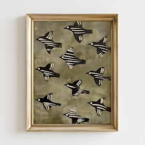 Könnte beinhalten: Gerahmtes Kunstwerk mit einer Gruppe stilisierter schwarz-weißer Vögel vor einem gedämpften grauen Hintergrund. Die Vögel sind in verschiedenen Flugphasen dargestellt, mit gestreiften Flügeln und einfachen Formen. Der Rahmen ist goldfarben.