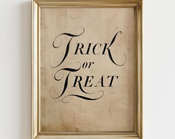 May include: A framed wall art piece featuring the black text Trick or Treat in a decorative, swirling script font. The background is a light tan, textured paper with a vintage, aged appearance. The frame is a metallic gold with a simple profile.