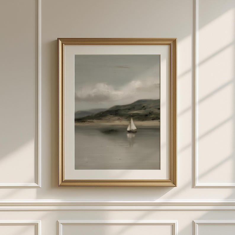 May include: A framed landscape painting featuring a sailboat on a calm body of water. The artwork has a muted color palette with a gold frame. The scene includes a distant shoreline and cloudy sky.