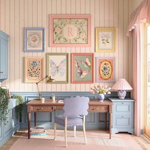 May include: A wooden desk with a scalloped-edge chair featuring a blue and white gingham pattern, positioned in front of a wall decorated with seven framed botanical and butterfly prints, a brass desk lamp, and a blue and white ceramic lamp.