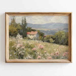 May include: A framed landscape painting depicts a rural scene with a house, trees, and a field of wildflowers. The artwork features a house with a red roof, surrounded by green trees and a field of pink and white flowers. The painting is in a gold-colored wooden frame.