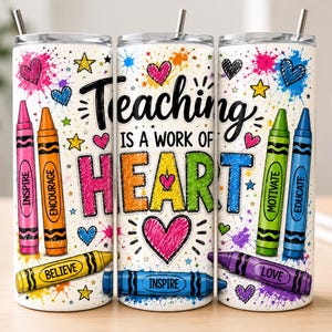 May include: A cylindrical tumbler with a white background featuring colorful crayon illustrations and paint splatters. The text reads Teaching is a work of heart, with individual crayons labeled Inspire, Encourage, Believe, Motivate, Educate, and Love.