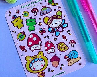 以下が含まれることがあります： 「Forest Friends」の文字が入ったステッカーシートには、キノコ、カエル、カタツムリなど、森の生き物の様々な漫画イラストが、気まぐれなスタイルで描かれています。ステッカーはピンク色の背景にあります。