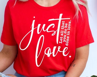 May include: A red t-shirt with the text "just love" in white lettering. The text is in a cursive font. The shirt also has the text "Let all that you do be done in love." in smaller white lettering.