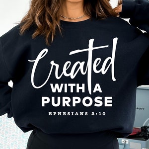 May include: Black sweatshirt with white text that reads "Created with a Purpose Ephesians 2:10".
