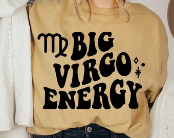 Puede incluir: Una camiseta amarilla mostaza con un gráfico negro que dice "Mr Big Virgo Energy" con un símbolo del zodíaco Virgo.