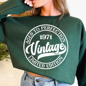 May include: A green sweatshirt with a white circle graphic that says "Aged to Perfection 1971 Vintage Limited Edition".