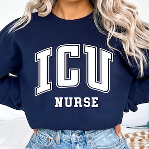 May include: A navy blue sweatshirt with white text that reads "ICU NURSE".