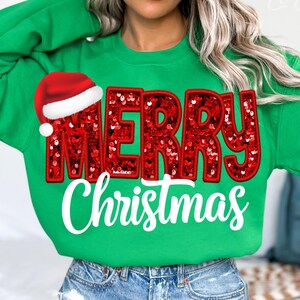 Puede incluir: Sudadera verde con un diseño de "Feliz Navidad" en lentejuelas rojas y un gorro de Papá Noel rojo.