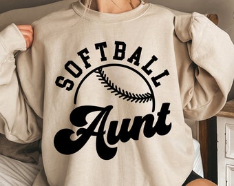 May include: A beige sweatshirt with the text "Softball Aunt" in black lettering and a softball graphic.
