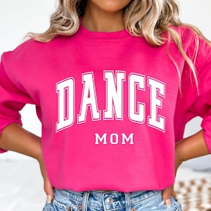 May include: A pink sweatshirt with the text "DANCE MOM" in white.