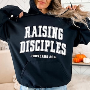 May include: Black hooded sweatshirt with white text that reads "Raising Disciples Proverbs 22:6"
