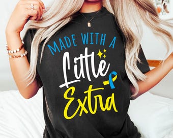 May include: A black t-shirt with the text "Made with a little extra" in white and yellow lettering. A blue and yellow ribbon is next to the text.
